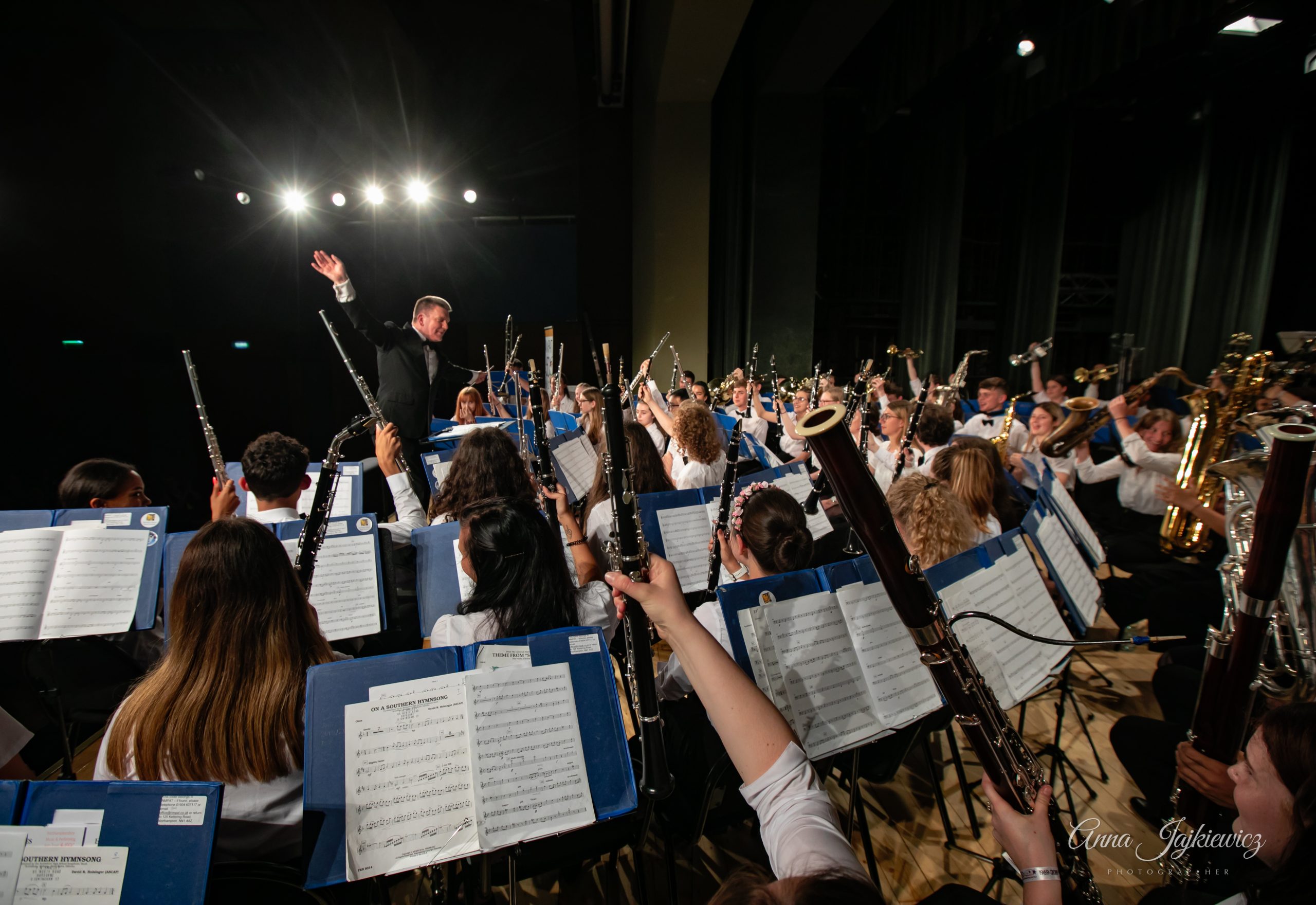 Orchestra performing on tour, instruments raised