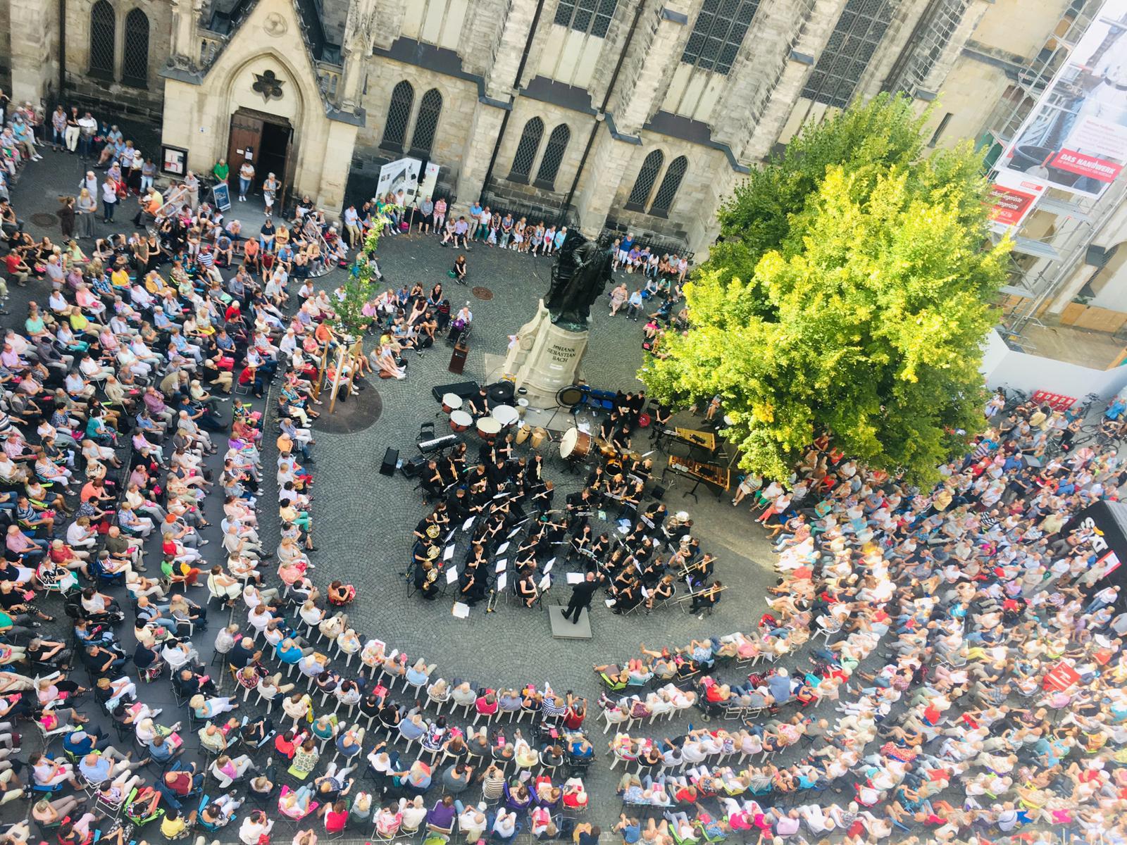 Orchestra perform to thousands of audience members, aerial view
