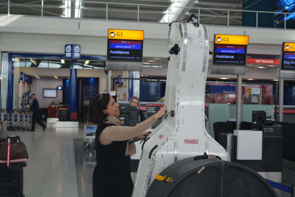 Staff member assisting the check in of a large double bass