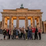 A group of people posing for a photo in front of Brandenburg Gate