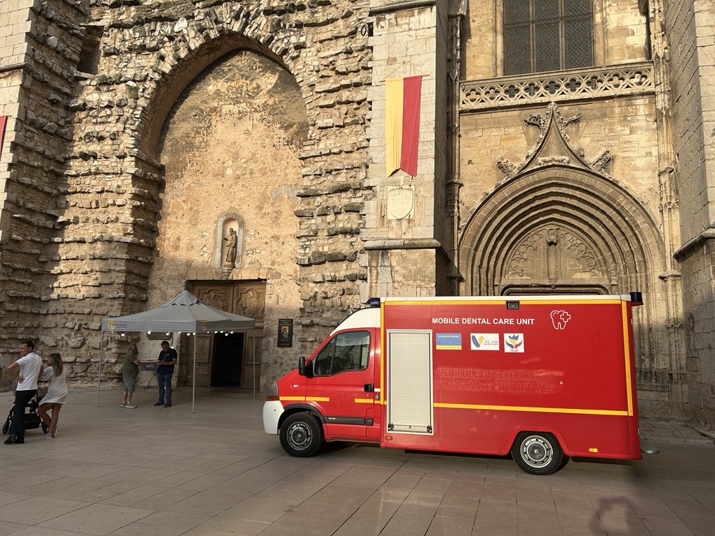 Picture of an ambulance parked outside a church in France